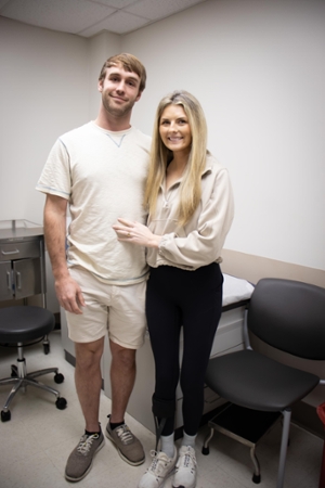 A young couple smiling in a medical exam room.